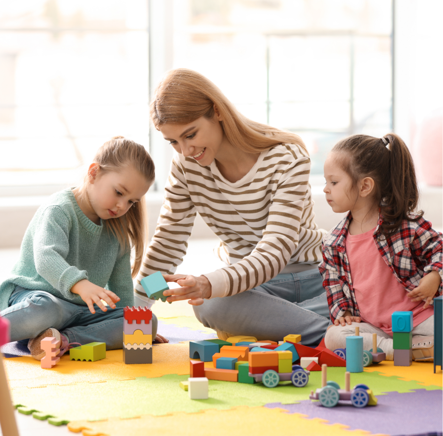 Dzieci, opiekunka bawiące się klockami w przedszkolu Urwis z Wejherowa