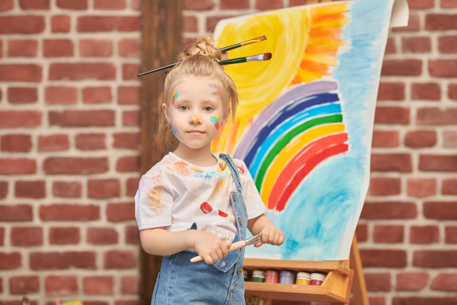Dziecięca wyobraźnia: radosna mała dziewczynka ubrudzona kolorowymi farbami - Przedszkole artystyczne w Wejherowie